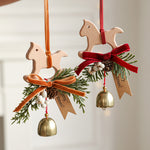 Suspension de Noël en bois — clochette, nœud et branche de pin