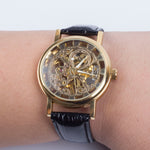 Montre mécanique squelette dorée à bracelet cuir noir