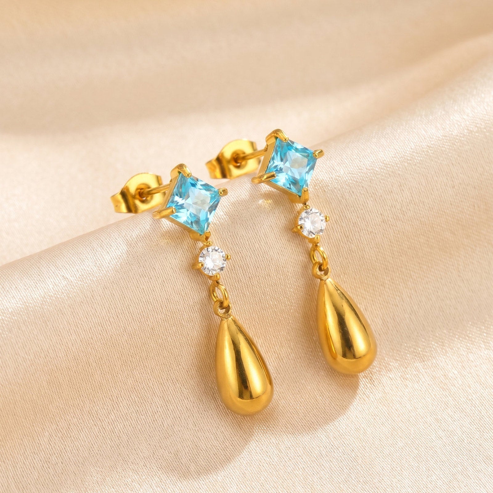 Boucles d’oreilles pendantes dorées — zircon bleu carré et goutte