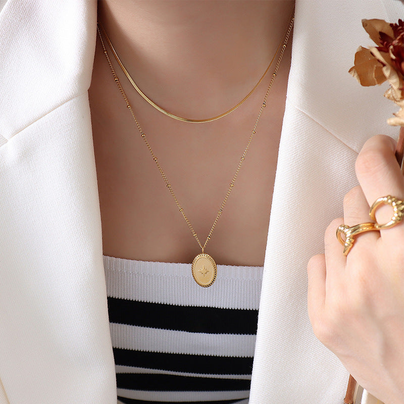 Collier double rang doré à médaillon ovale gravé d’une étoile