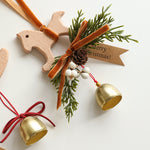 Suspension de Noël en bois — clochette, nœud et branche de pin