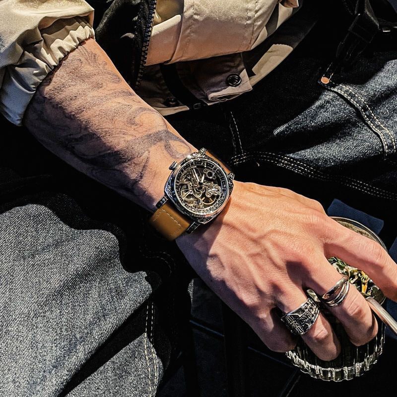Automatisch herenhorloge met gegraveerde kussenvormige kast en skeletwijzerplaat