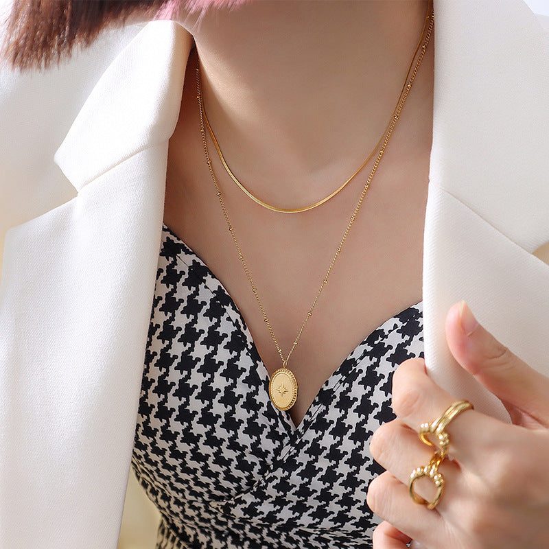 Colar duplo dourado com medalhão oval gravado com uma estrela